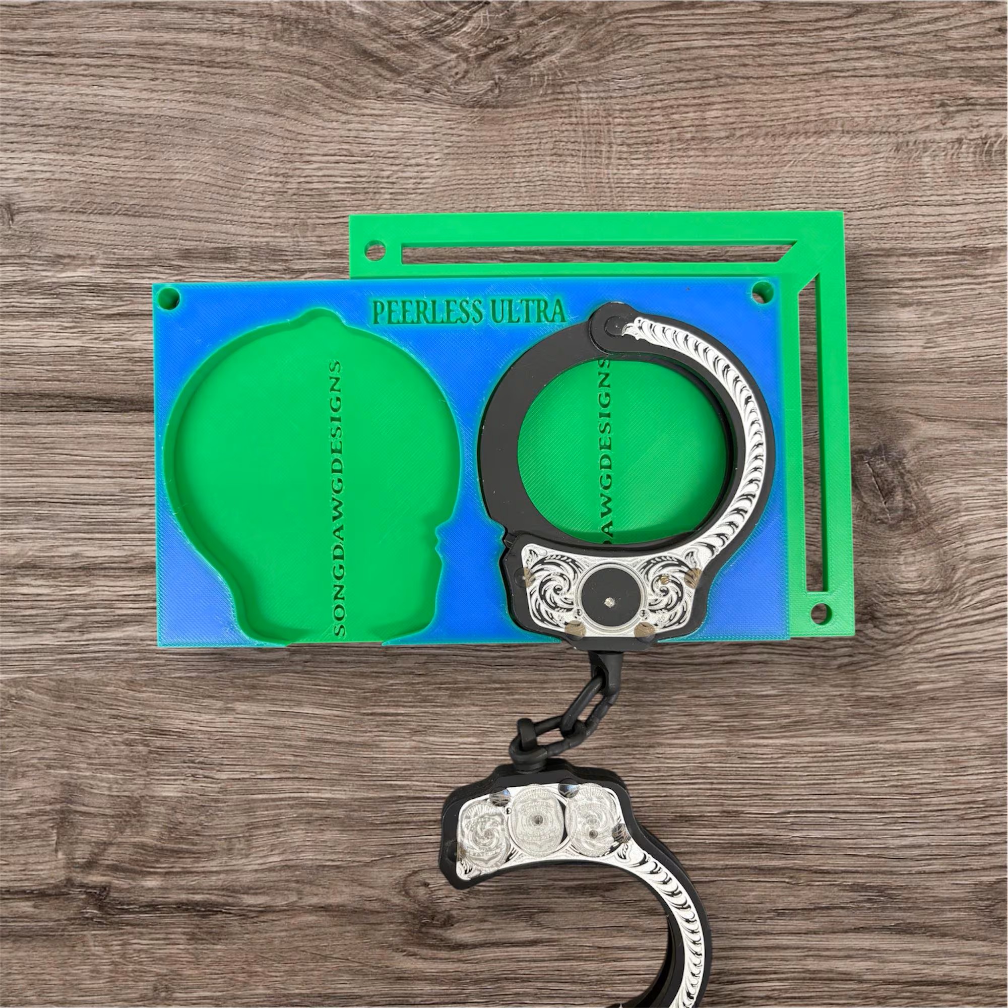 Handcuff jig on workbench with engraved cuffs
